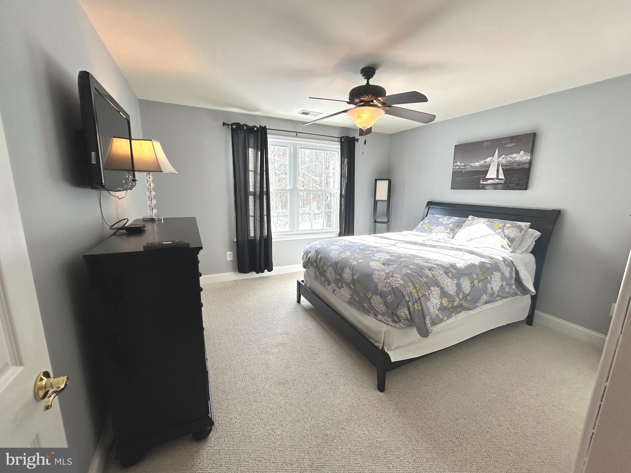 2720 Emmanuel Church Road Huntingtown, MD 20639 - Photo 37 of 85 a bedroom with a bed and a flat tv screen on dresser