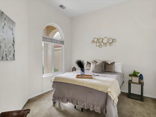 a bedroom with a bed and a potted plant