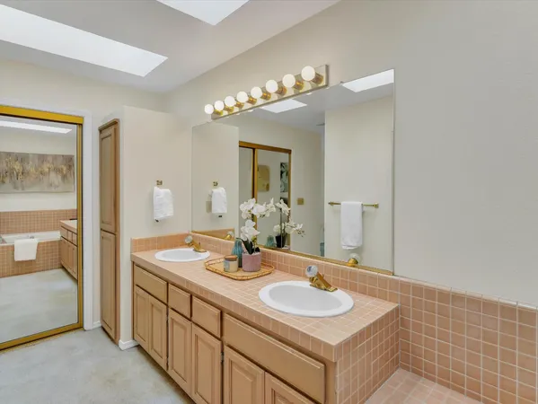 a bathroom with a sink a large mirror and a bathtub