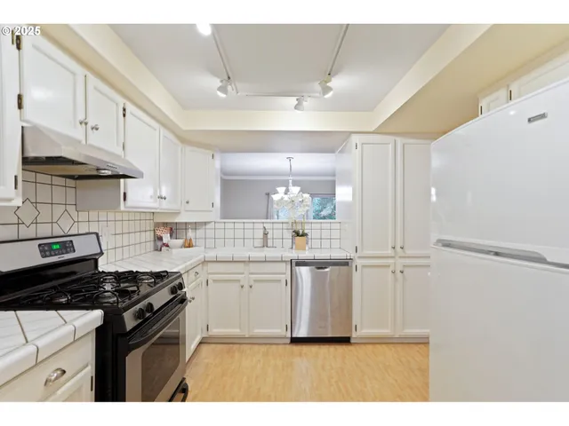 a kitchen with kitchen island white cabinets and appliances