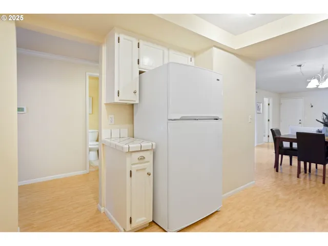 a kitchen with refrigerator a table and chairs