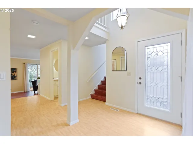 a view of a hallway to rooms and stairs