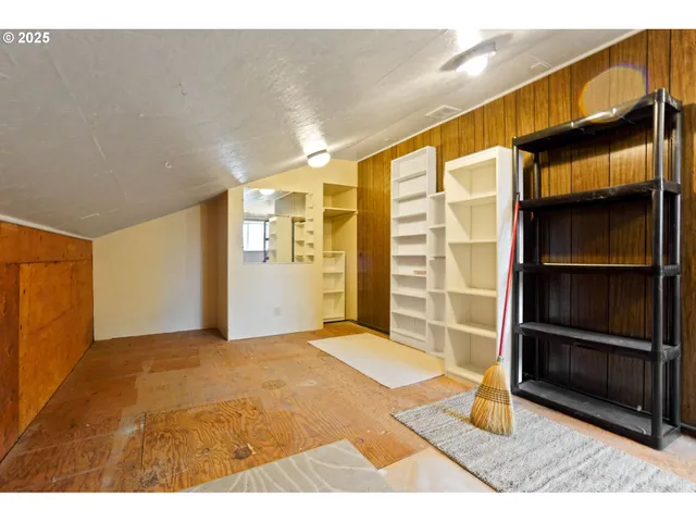 a view of an empty room with closet and a window