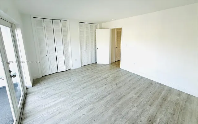 an empty room with wooden floor and a window