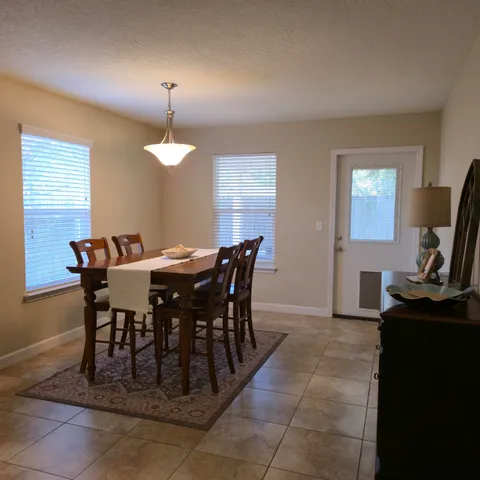 a view of a dining room with furniture and a chandelier