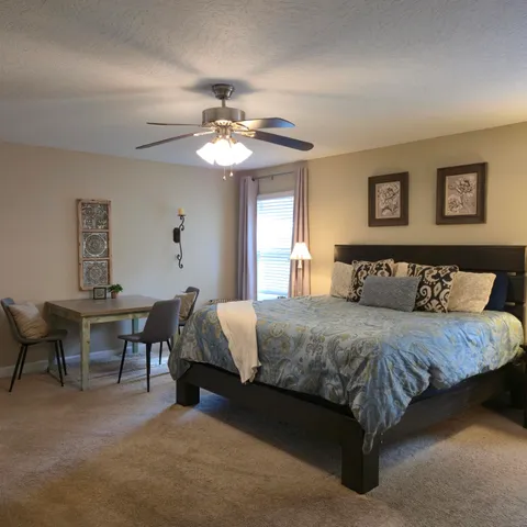 a spacious bedroom with a bed and a chandelier