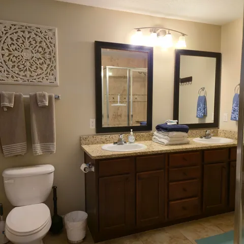 a bathroom with a granite countertop toilet sink and mirror