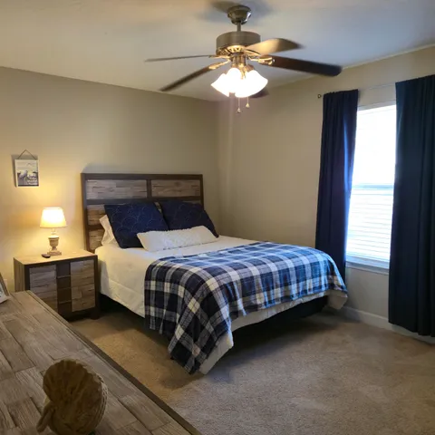 a bedroom with a bed dresser and a chandelier