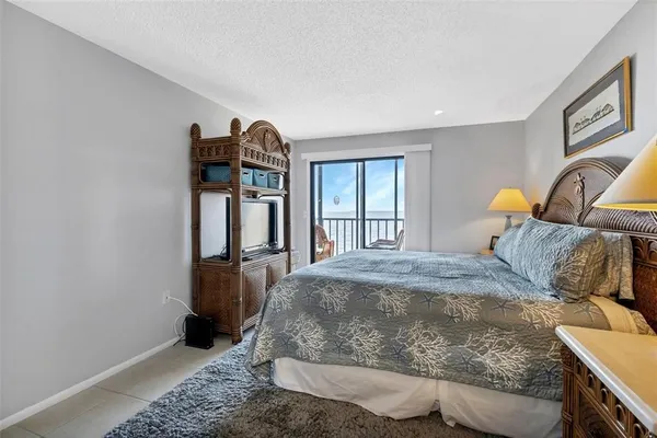 a bedroom with a bed and a lamp on dresser