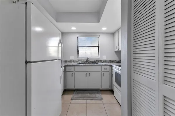 a kitchen with cabinets appliances a sink and a window