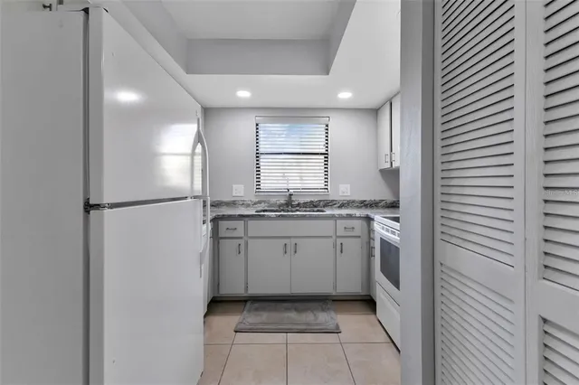 a kitchen with cabinets appliances a sink and a window