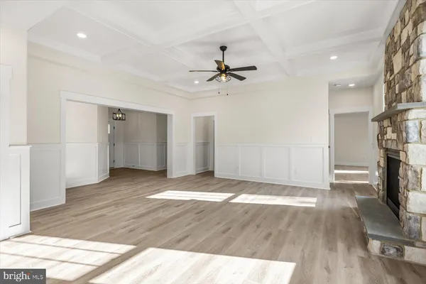 an empty room with windows and ceiling fan