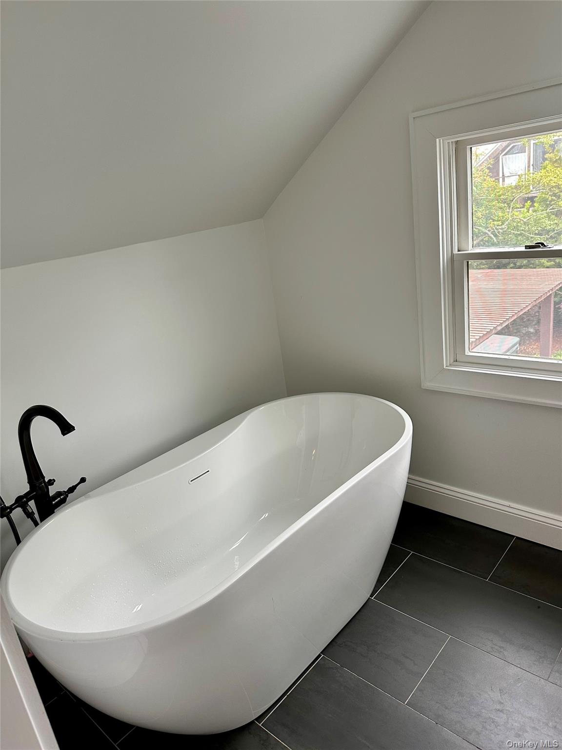 19 Ocean Road Ocean Beach, NY 11770 - Photo 14 of 20 Bathroom featuring lofted ceiling, a soaking tub, and baseboards