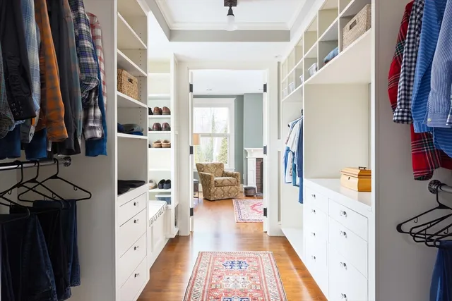 a hallway with white cabinets and wooden floor