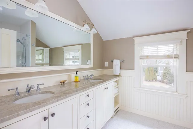a bathroom with double sink and a window
