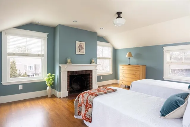 a bedroom with two beds and a fireplace