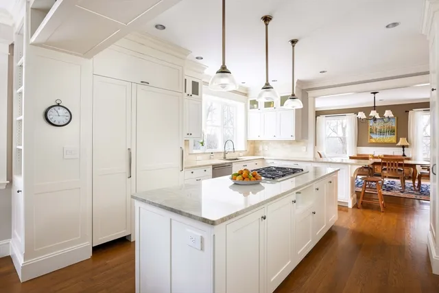 a kitchen that has a lot of cabinets a sink and wooden floor