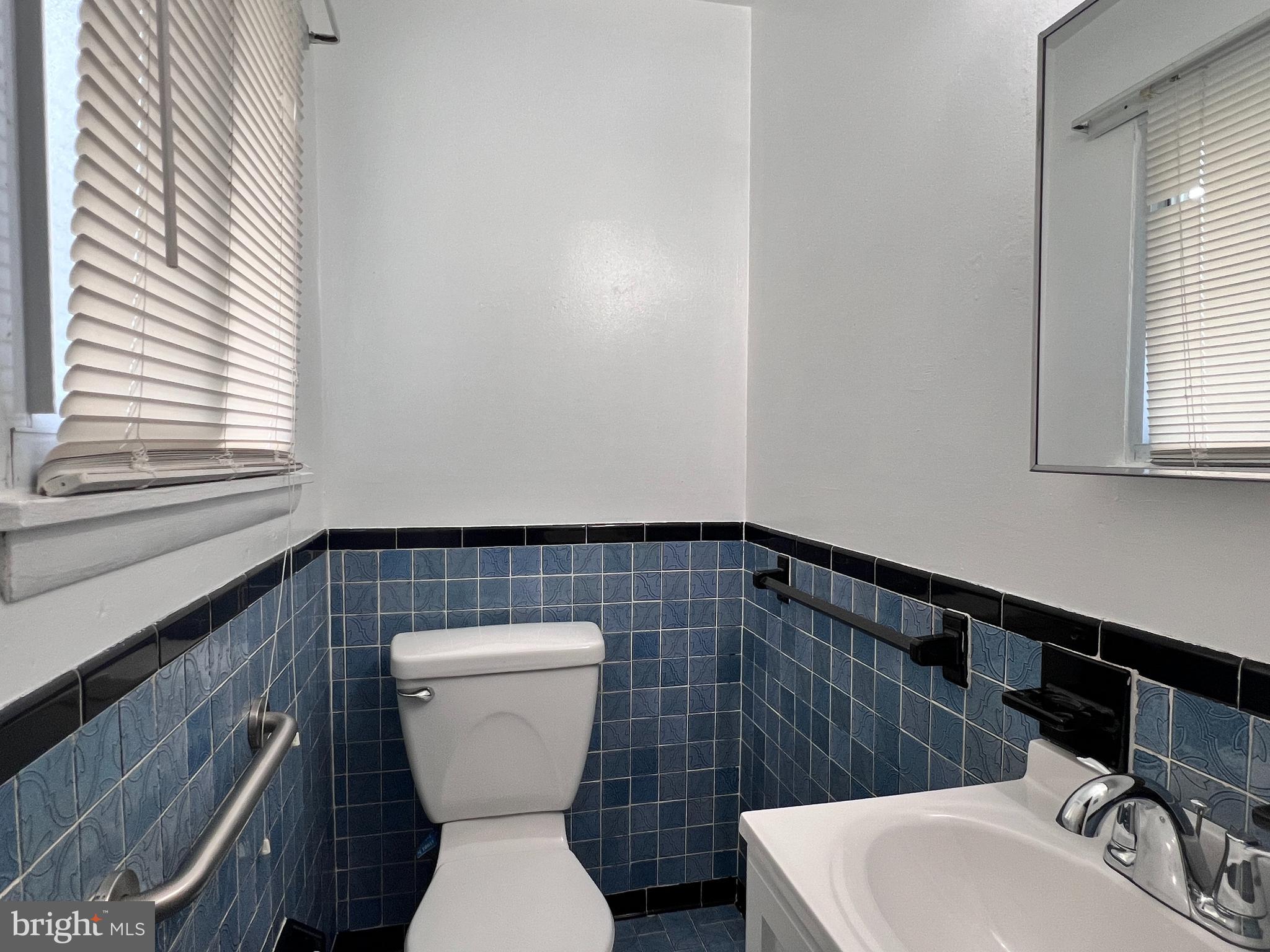 8702 Hamlin Street, Unit A Landover, MD 20785 - Photo 11 of 15 a bathroom with a sink a toilet and a mirror