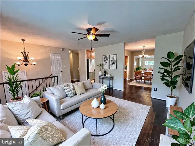 a view of a livingroom with wooden floor and a ceiling fan
