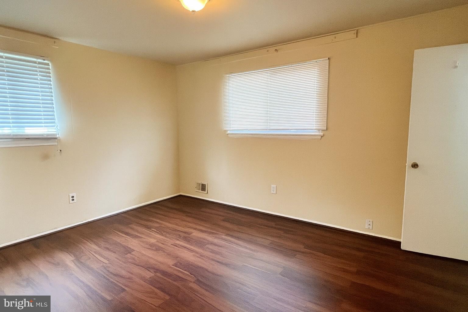 8702 Hamlin Street, Unit A Landover, MD 20785 - Photo 9 of 15 an empty room with wooden floor and windows