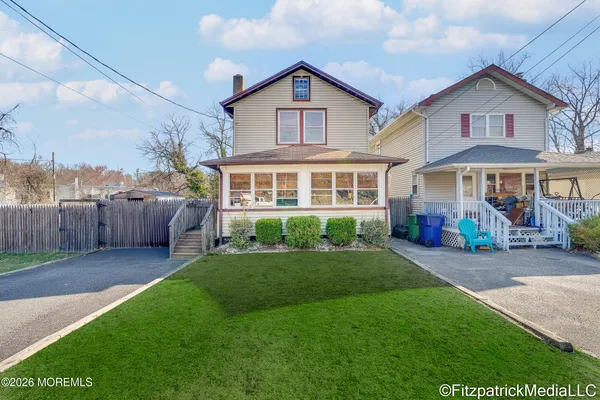 a front view of a house with a yard and fence
