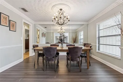a view of a dining room with furniture a chandelier and wooden floor