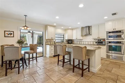 a kitchen with granite countertop white cabinets and sink