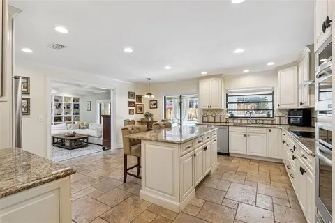 a kitchen with white cabinets appliances and a counter top space