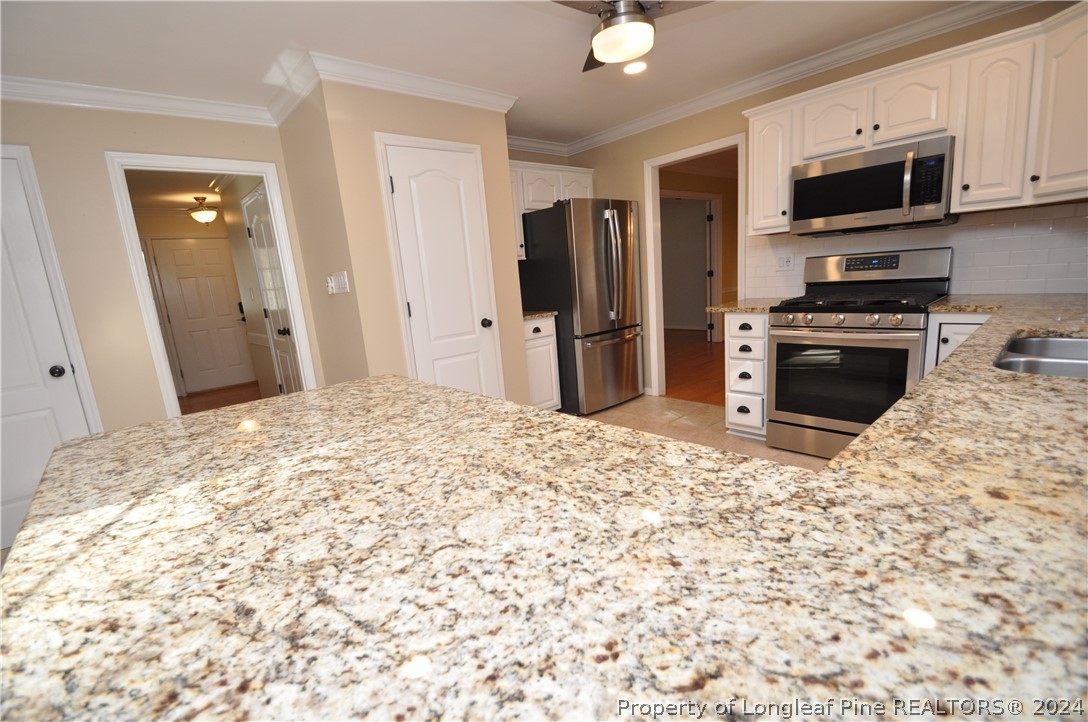 Undisclosed Address Cary, NC 27513 - Photo 17 of 50 a kitchen with stainless steel appliances kitchen island granite countertop a refrigerator and a stove top oven