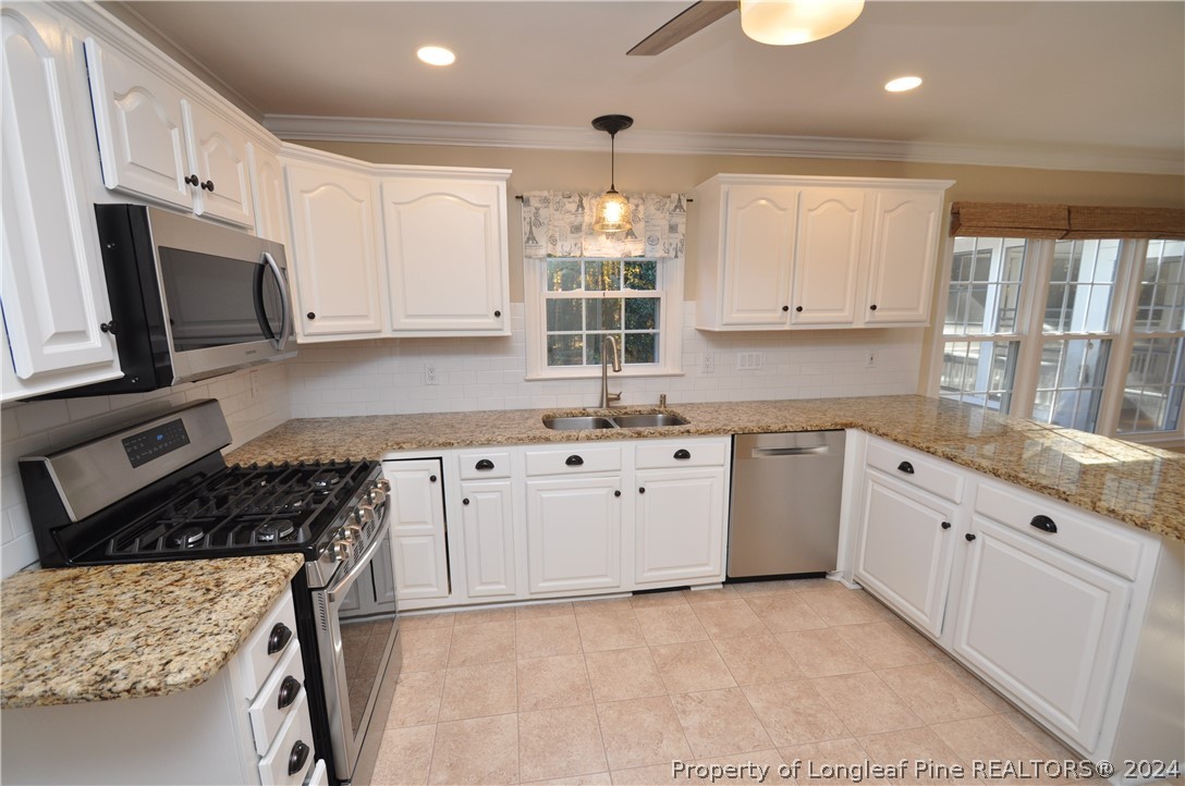 Undisclosed Address Cary, NC 27513 - Photo 18 of 50 a kitchen with granite countertop white cabinets white stainless steel appliances with a sink and dishwasher