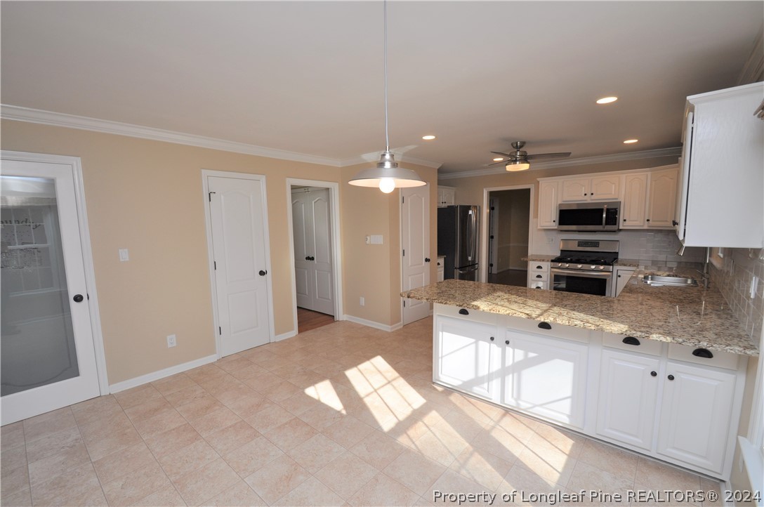 Undisclosed Address Cary, NC 27513 - Photo 27 of 50 a large white kitchen with kitchen island granite countertop a sink and white cabinets