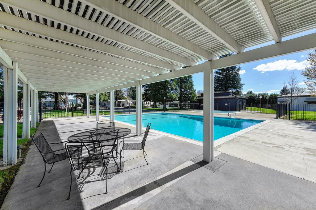14789 Jurata Court Rancho Murieta, CA 95683 - Photo 31 of 36 a patio with a table and chairs and couches with wooden roof and fence
