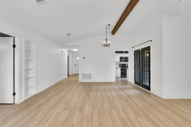 a view of empty room with wooden floor and entryway
