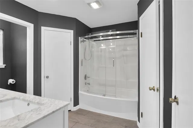 a bathroom with a granite countertop bathtub shower sink and mirror