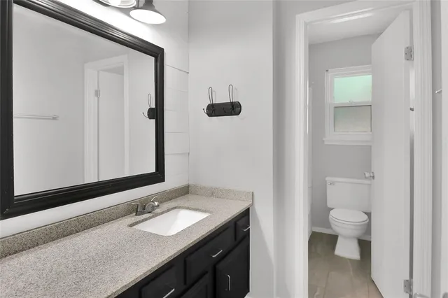 a bathroom with a granite countertop sink and a mirror