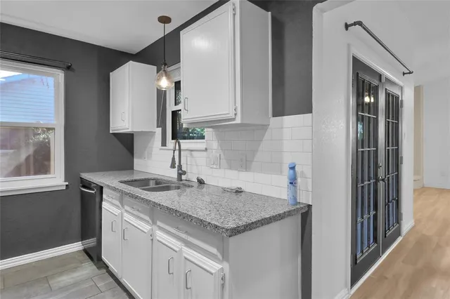 a kitchen with a granite countertop sink and a refrigerator