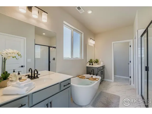 a bathroom with a granite countertop sink a mirror a bathtub and shower