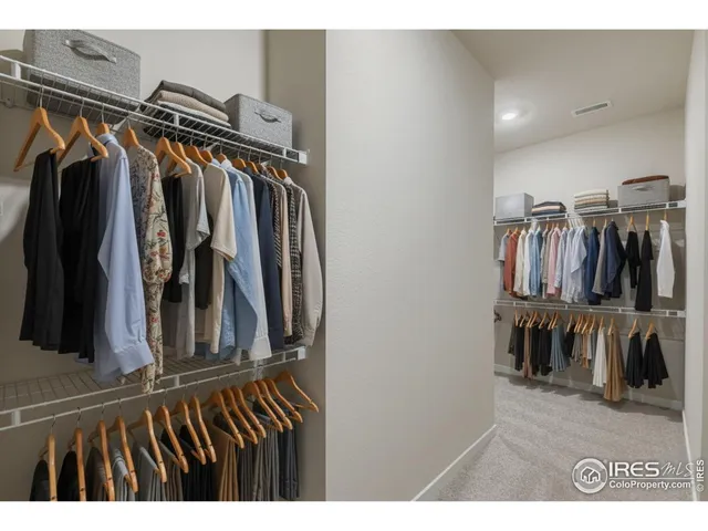 a view of walk in closet with clothes and shoes