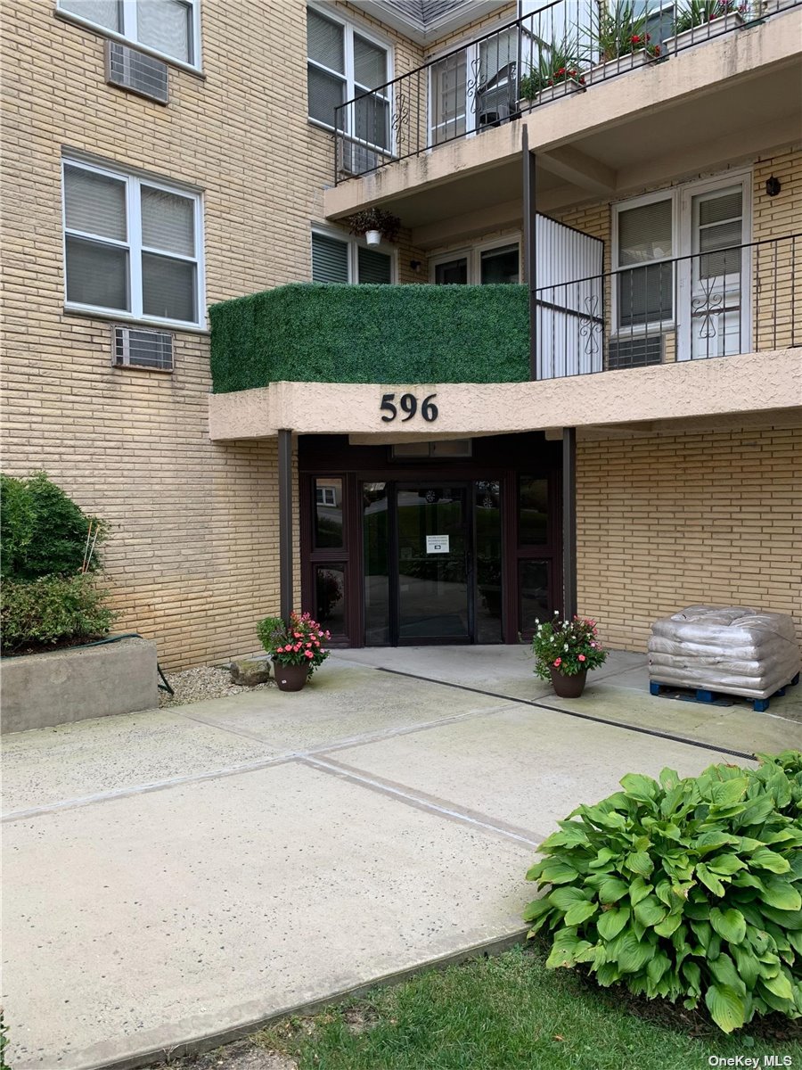 596 Broadway, Unit 18B Lynbrook, NY 11563 - Photo 1 of 1 a view of a house with potted plants and a yard