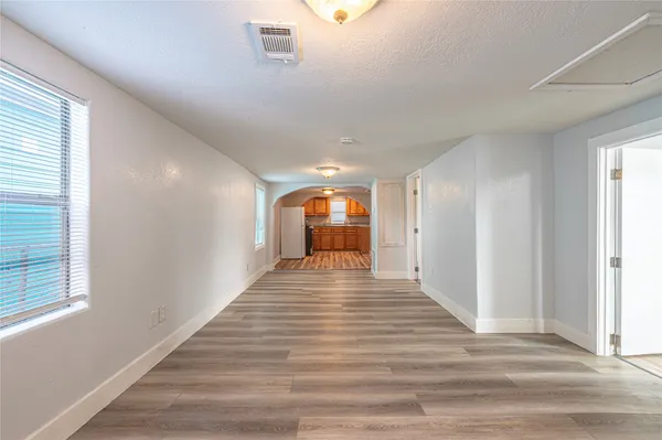 a view of empty room with window and wooden floor