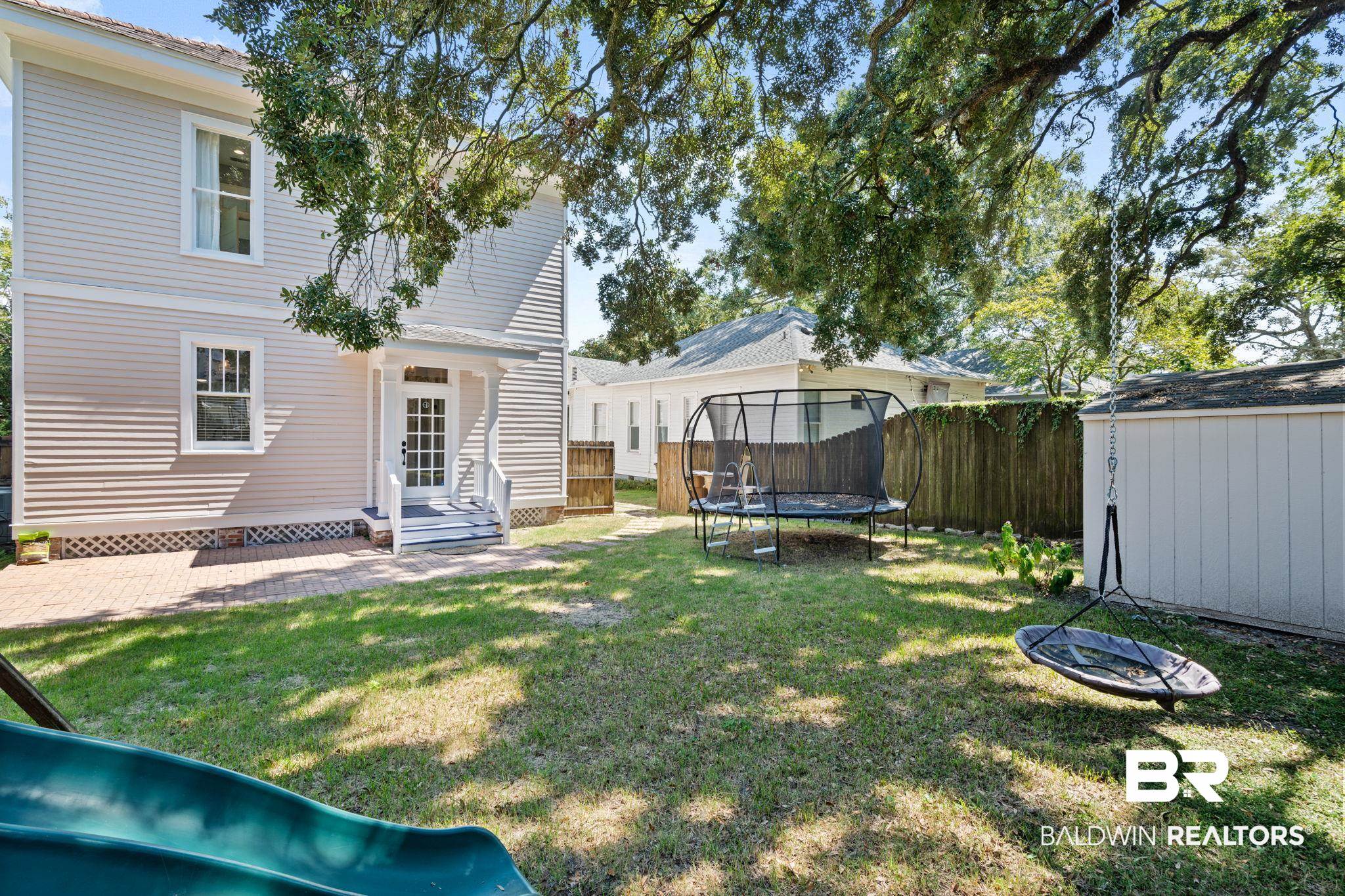 10 South Monterey Street Mobile, AL 36604 - Photo 36 of 45 View of yard with a trampoline, a patio area, and a storage unit
