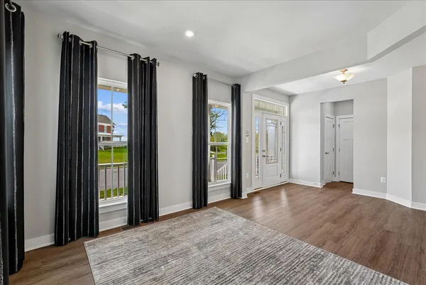 a view of empty room with wooden floor and bathroom