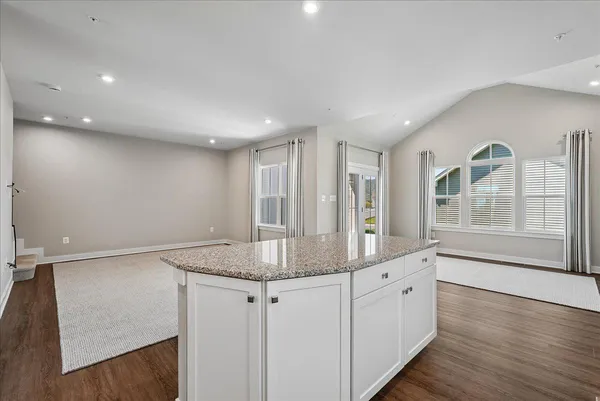 a kitchen with stainless steel appliances granite countertop a refrigerator a stove a sink and white cabinets
