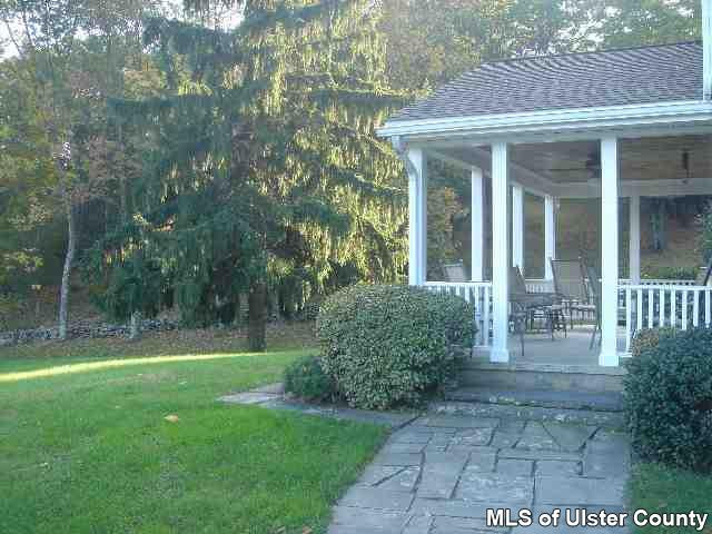 60 Peak Farm Road, Unit 5 000 SELLING BONUS Stone Ridge, NY 12484 - Photo 4 of 4 a view of a house with brick walls and a yard with plants