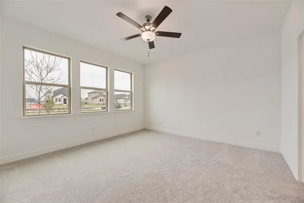 an empty room with windows and fan