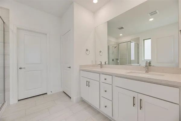 a bathroom with double sink and a mirror