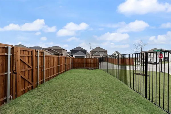 a view of a backyard with wooden fence