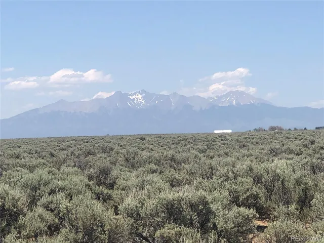 a view of a dry yard with mountains in the background
