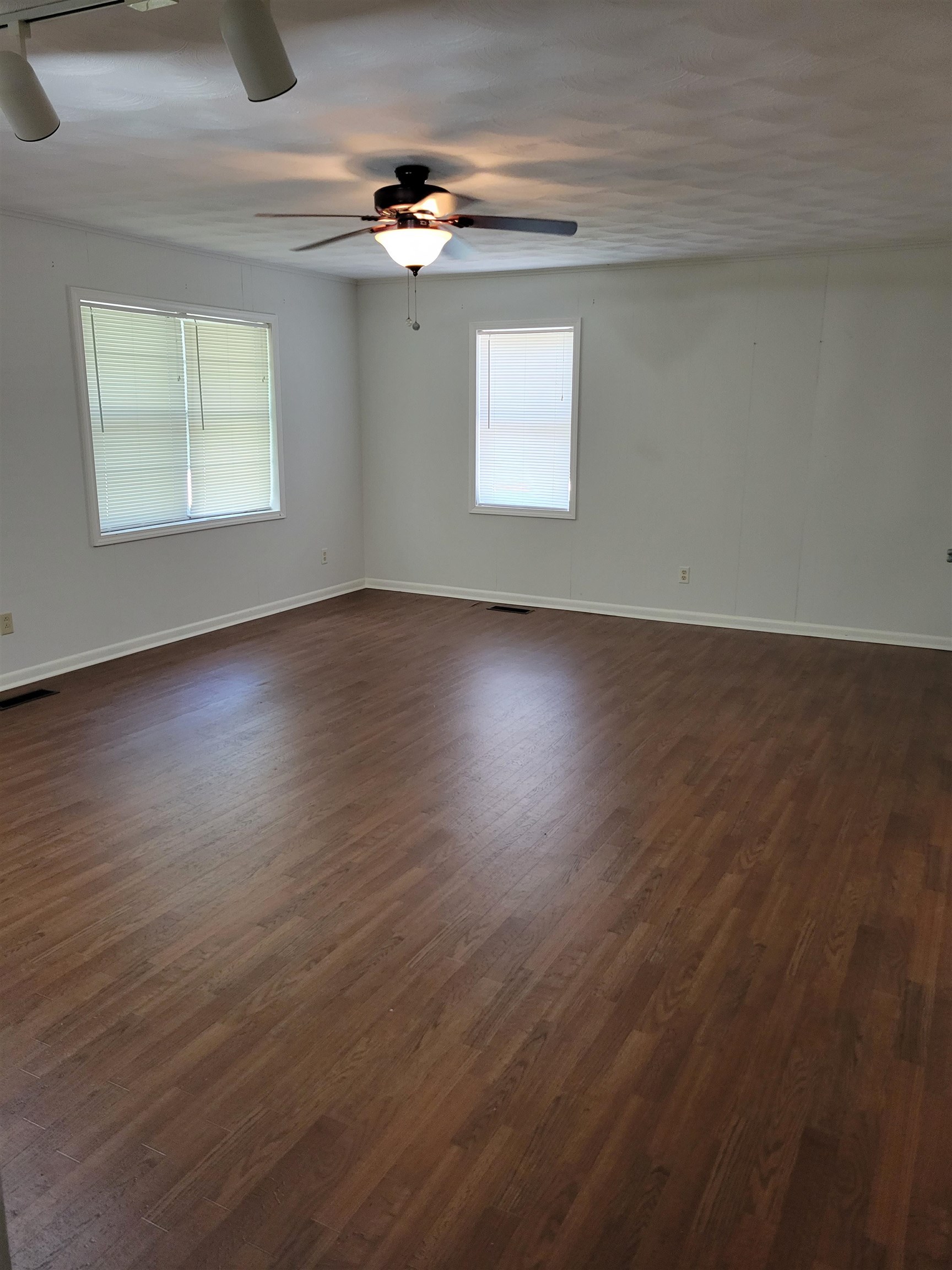 1572 Asbury Glimp Road Ripley, TN 38063 - Photo 12 of 20 an empty room with wooden floor chandelier and windows