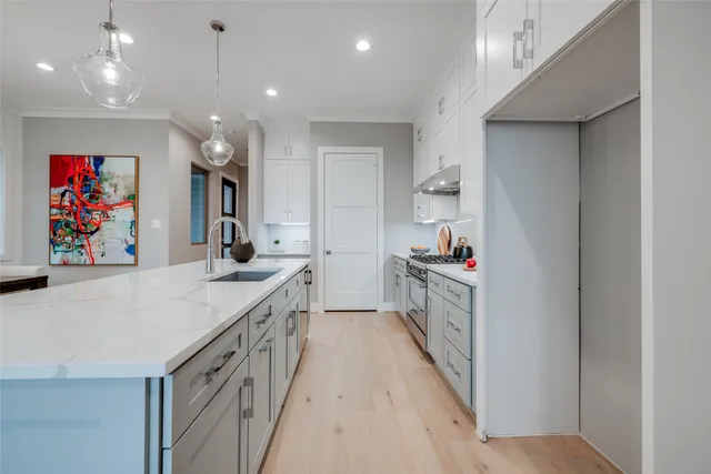 a kitchen with white cabinets stainless steel appliances and a counter space